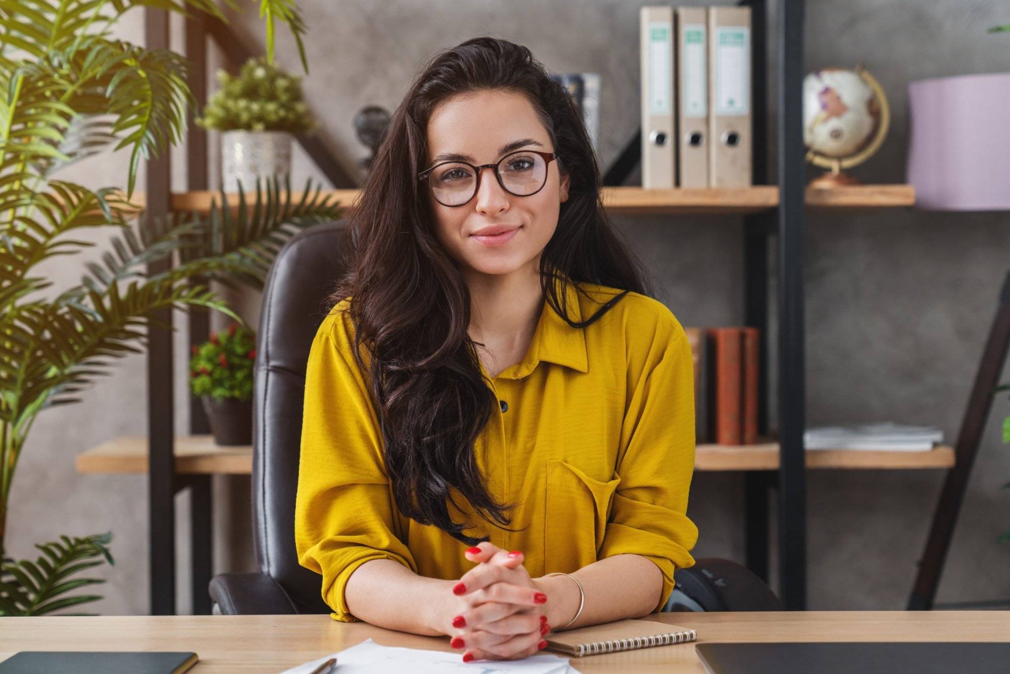 Successful business woman working at office with look at camera