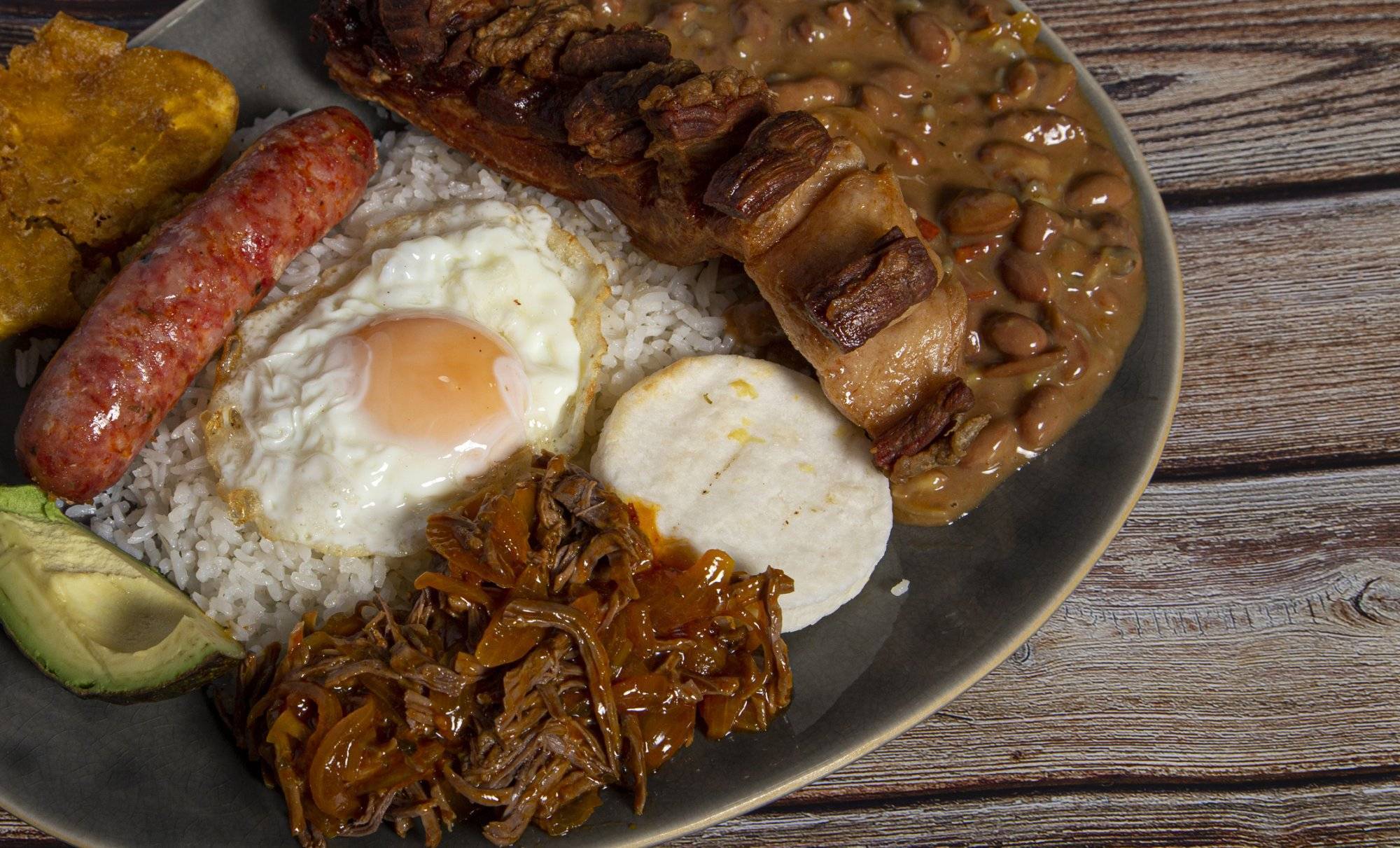 Bandeja paisa, typical dish of Colombia. It consists of chicharrón (fried pork belly), black pudding, sausage, arepa, beans, fried banana, avocado egg and rice